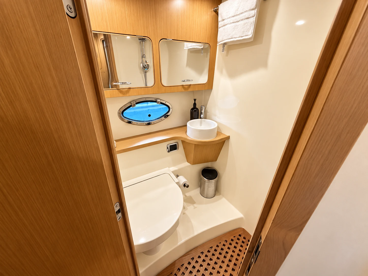 On-board bathroom with porthole, washbasin and teak grating