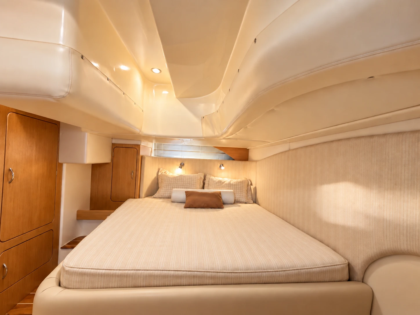 Double cabin with a made-up bed, reading lights and teak cupboards