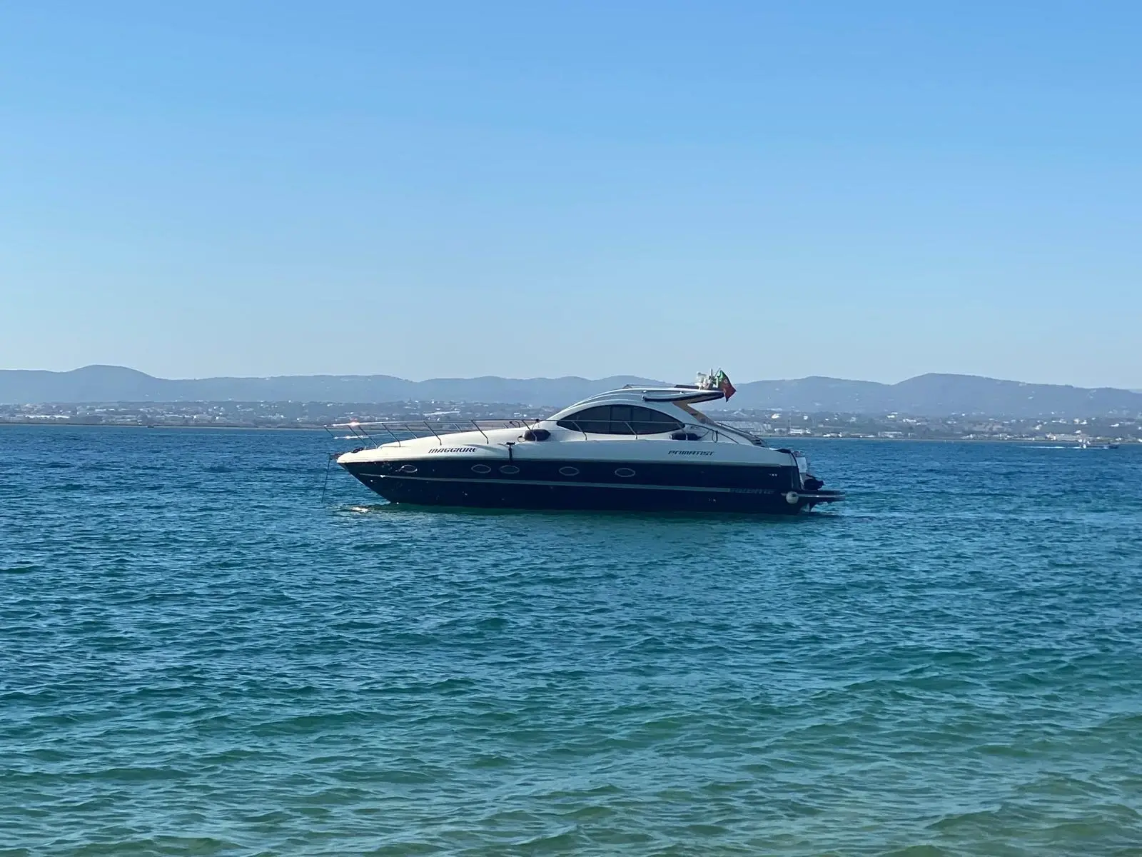 The yacht at anchor on blue water under a clear sky